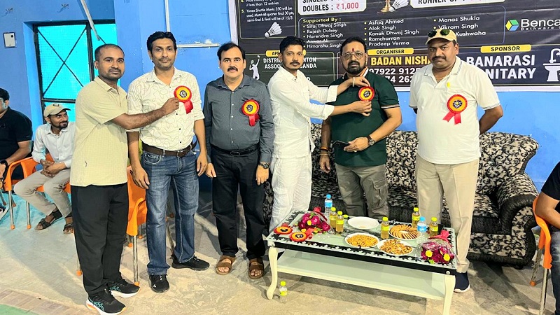 अतिथियों को बैच लगाते कोच। 