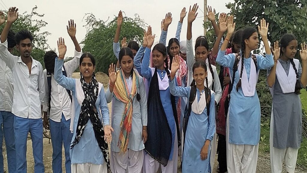 सड़क के लिए प्रदर्शन करतीं स्कूली छात्राएं।