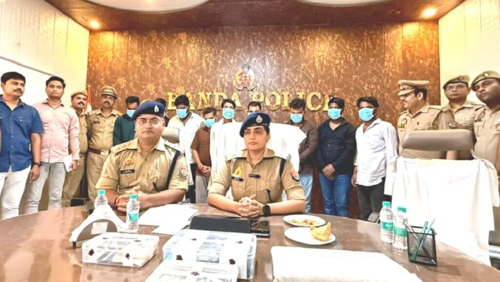पुलिस अधिकारी और हिरासत में 9 साइबर ठग।