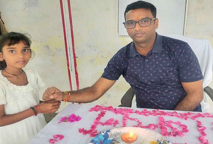 बांदा जेल में रक्षा बंधन पर जेल अधीक्षक को राखी बांधती बच्ची।