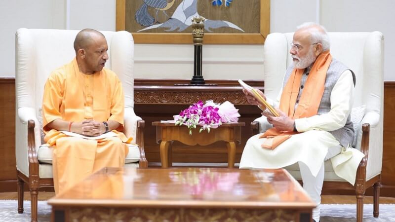 सीएम योगी और पीएम मोदी आपस में चर्चा करते हुए।