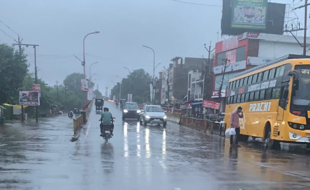 बांदा में बारिश के रेड अलर्ट में भारी बरसात में वाहन।