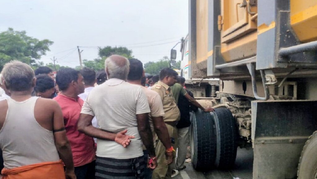 बांदा के तिंदवारी में हादसे के बाद मौके पर भीड़ और ट्रक जांचती पुलिस